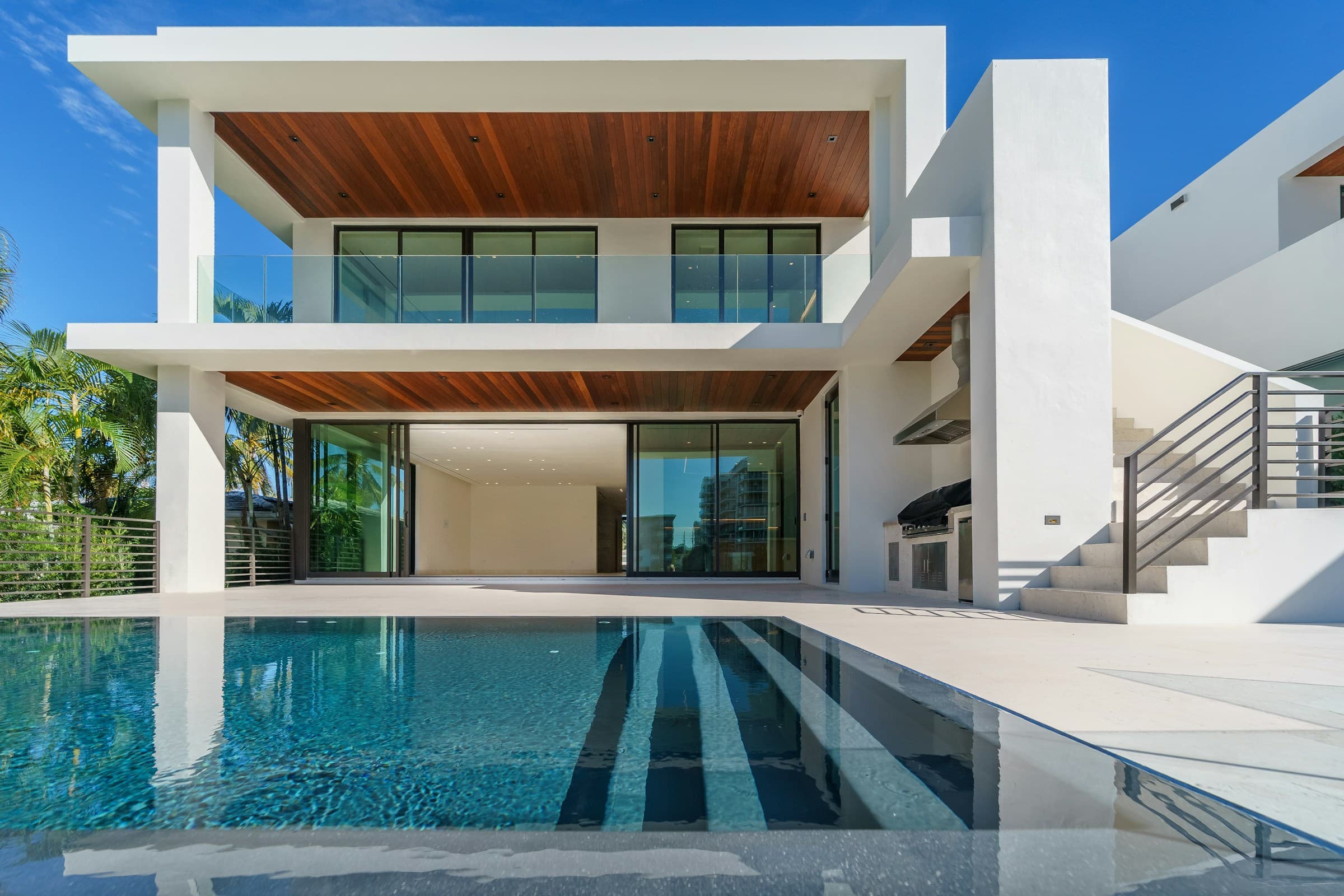 Modern villa in white concrete and wood, with a pool and large glazing