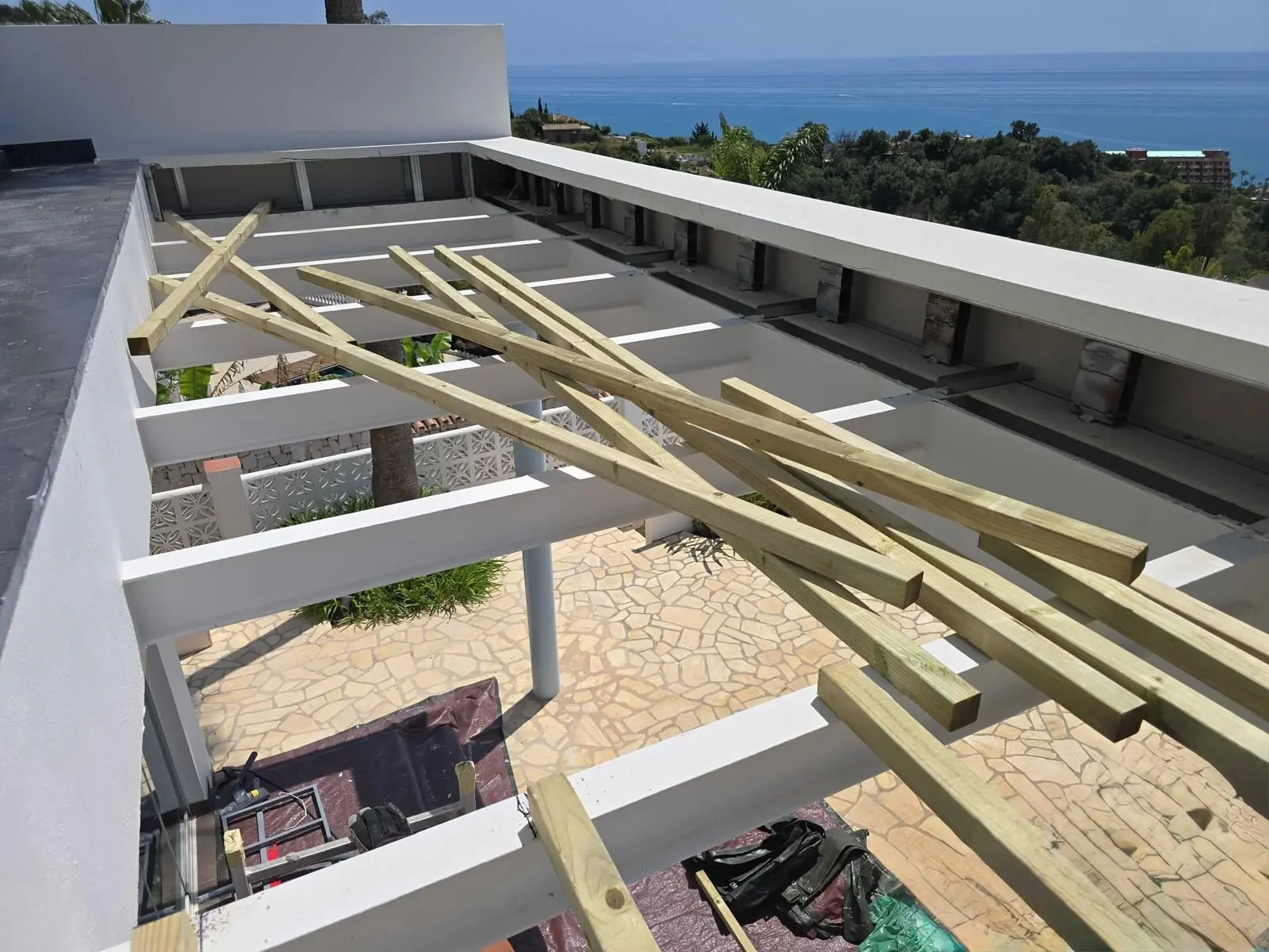 Timber pergola frame under construction with sea views in a Costa del Sol community